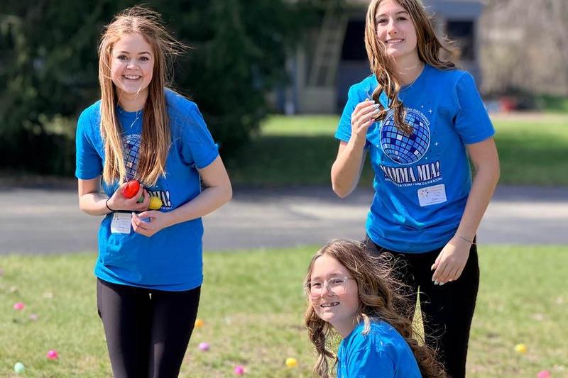 (Kneeling) Riley Conley, (L) Aubrey Brooke, and (R) Clare Wilson busy themselves with hiding hundreds of plastic eggs