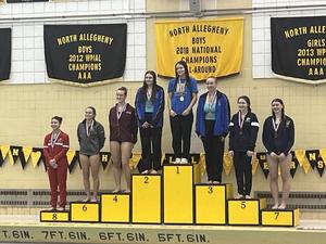 divers standing on a podium with medals around their necks