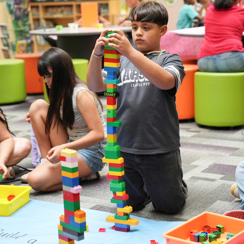 student plays with legos during family STEAM event