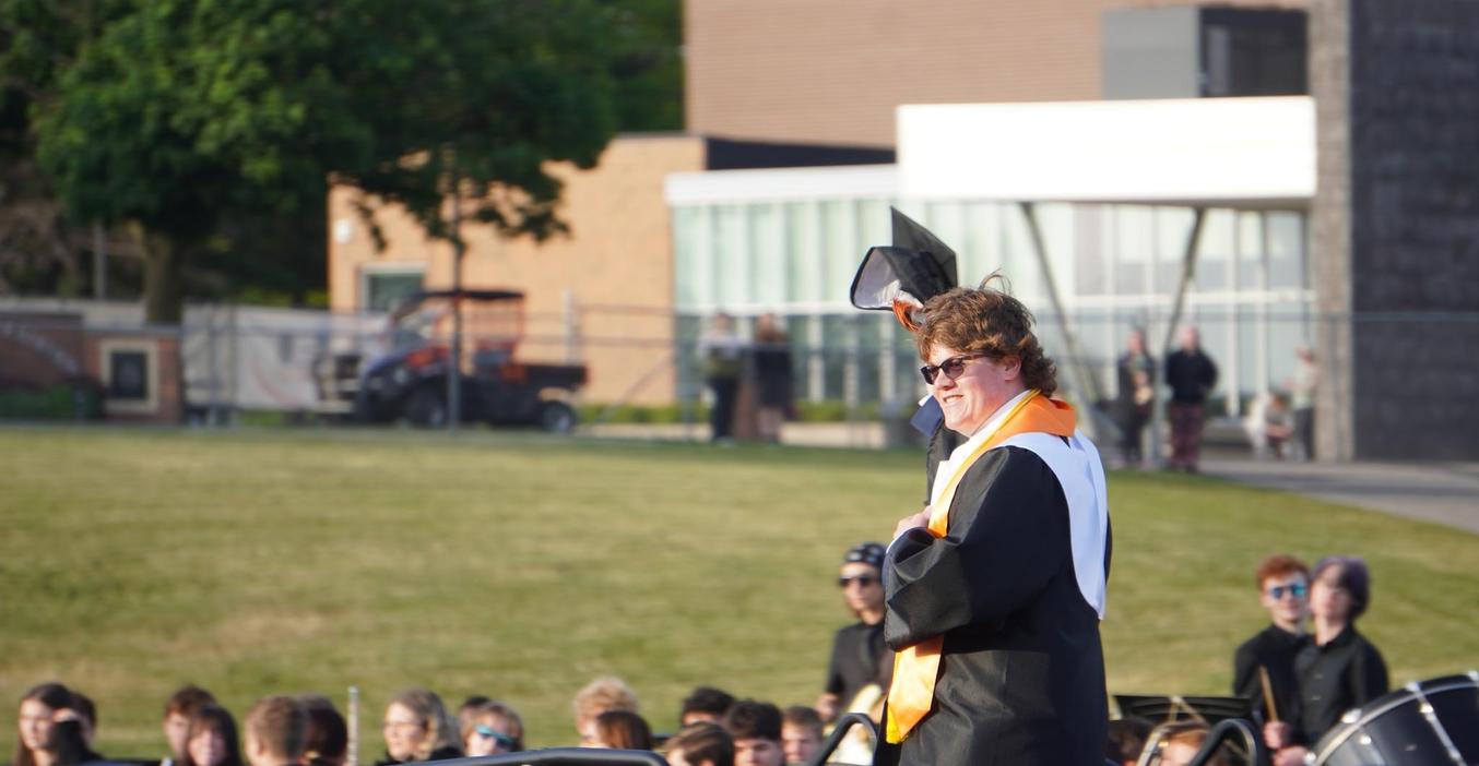 Graduate in cap and gown joyfully celebrating at a graduation ceremony.