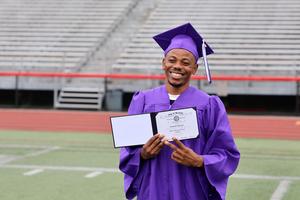 graduate poses with diploma
