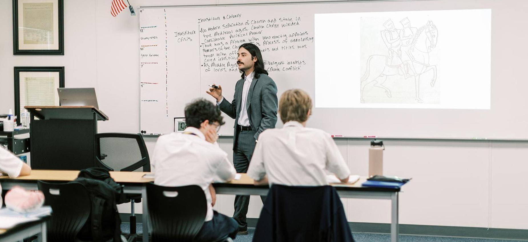 Teacher in a suit leads a history lesson for high school students