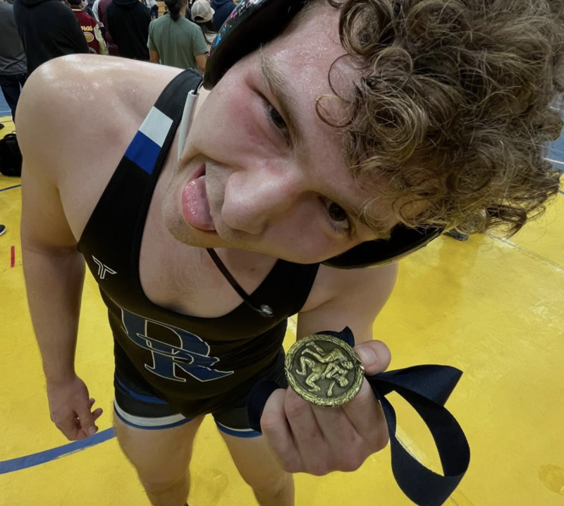 student holding up medal