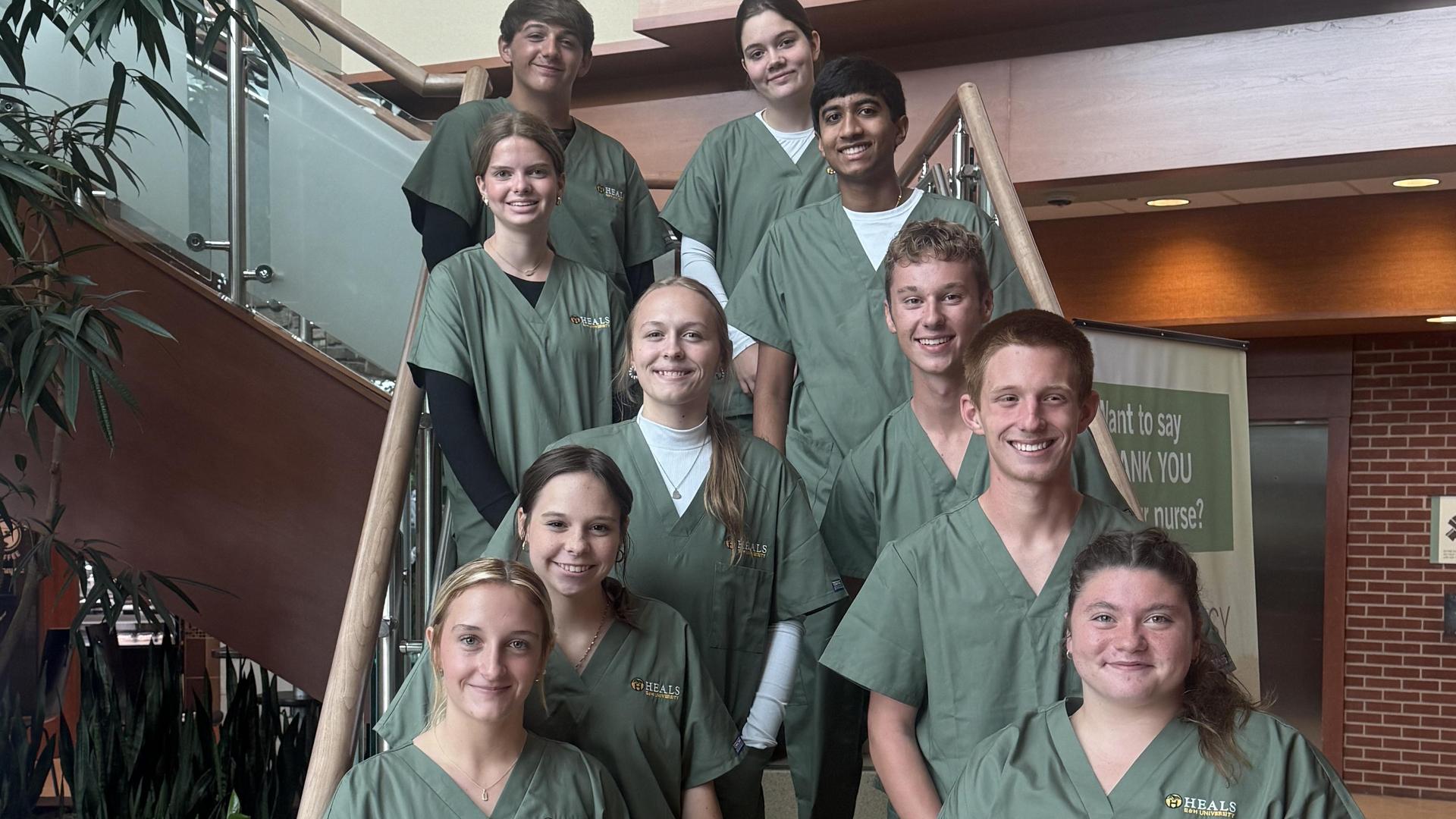HEALS students on stairway in green scrubs