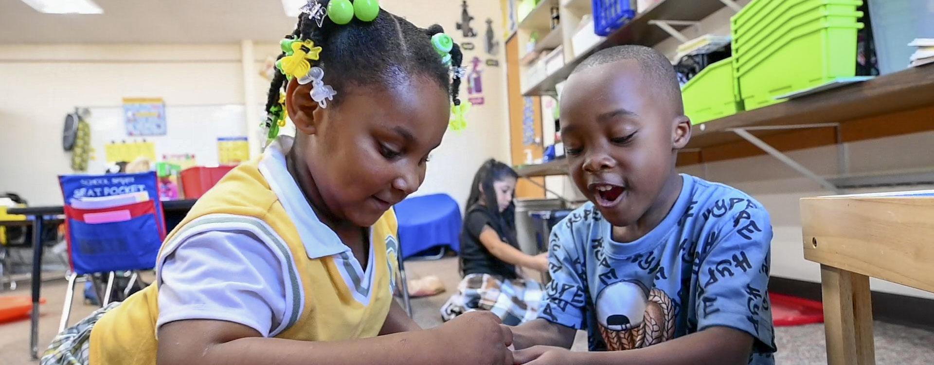 Two students playing with blocks together