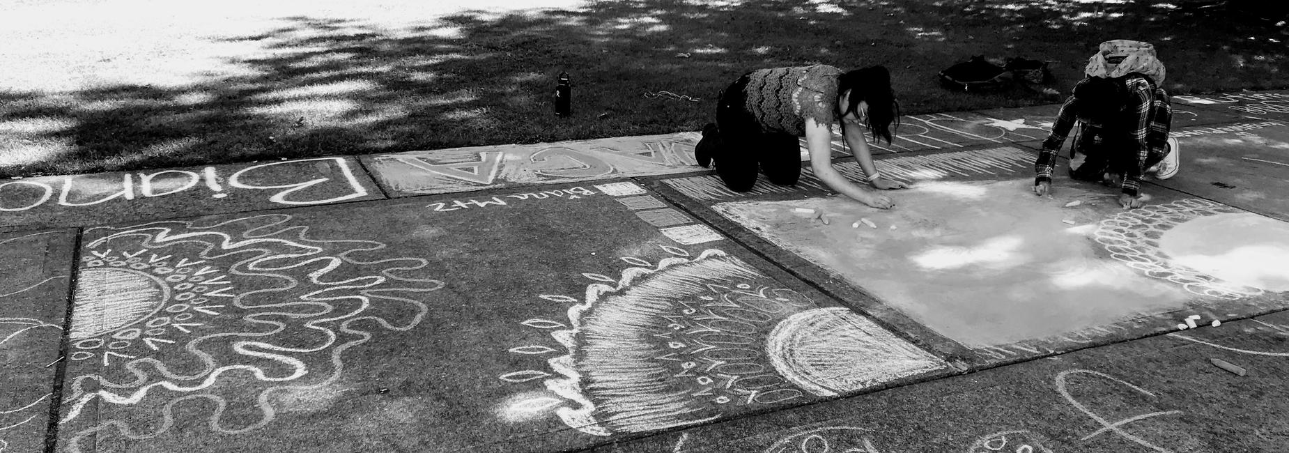 Students drawing with chalk at awards afternoon