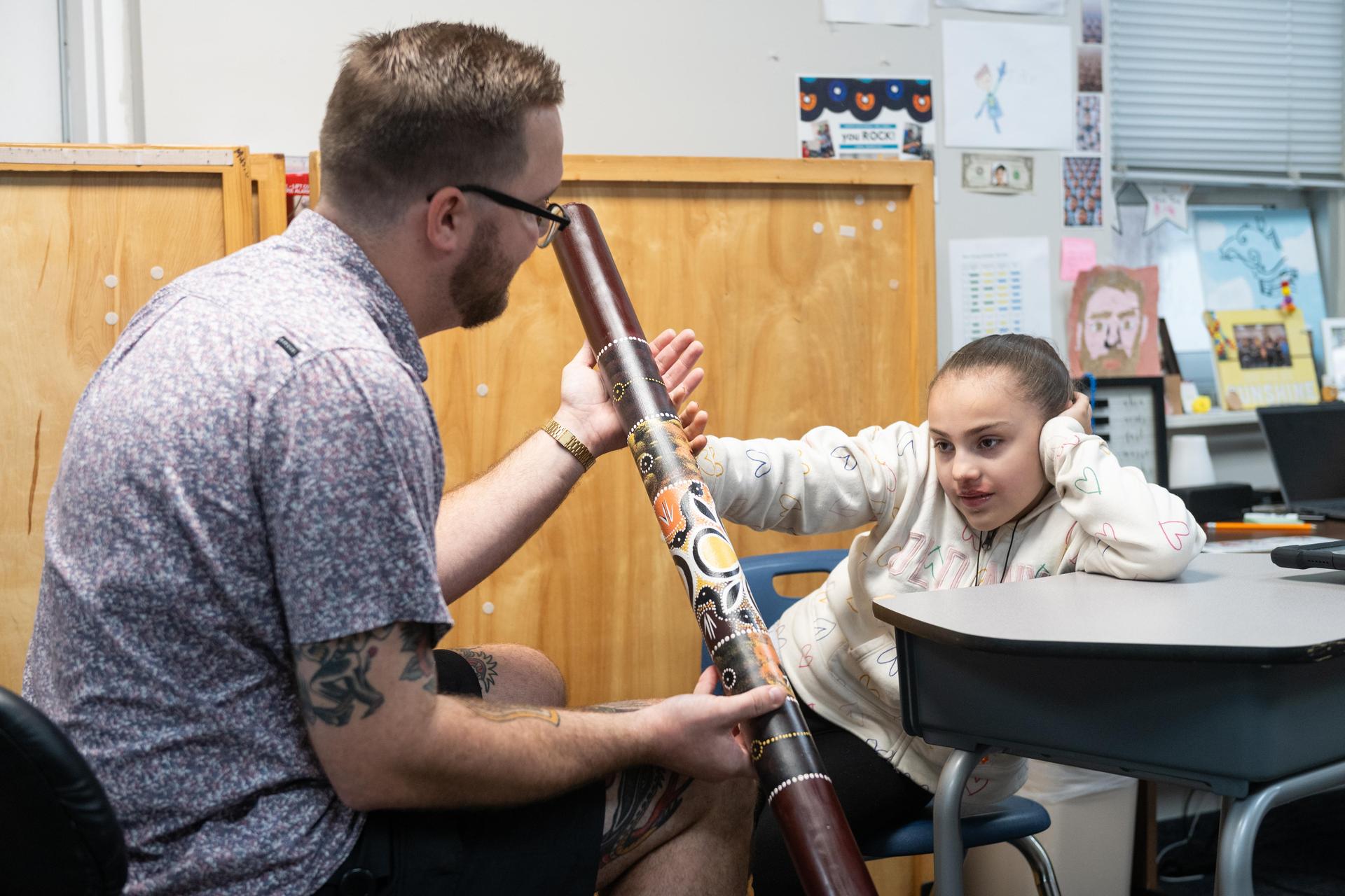 Teacher holding instrument for student.