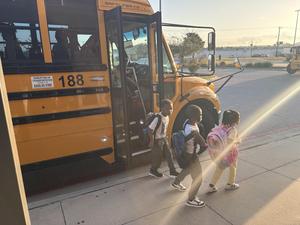 Students get off the bus on the first day of school