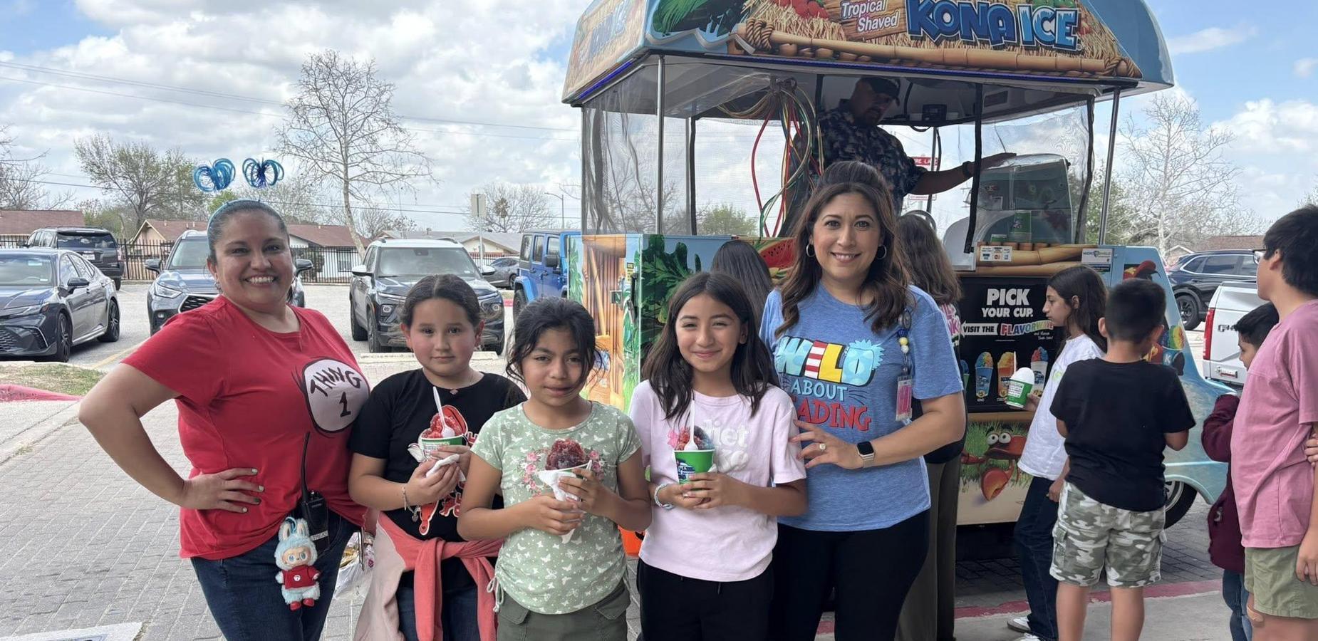 Group of children and adults enjoying treats from a snow cone truck.