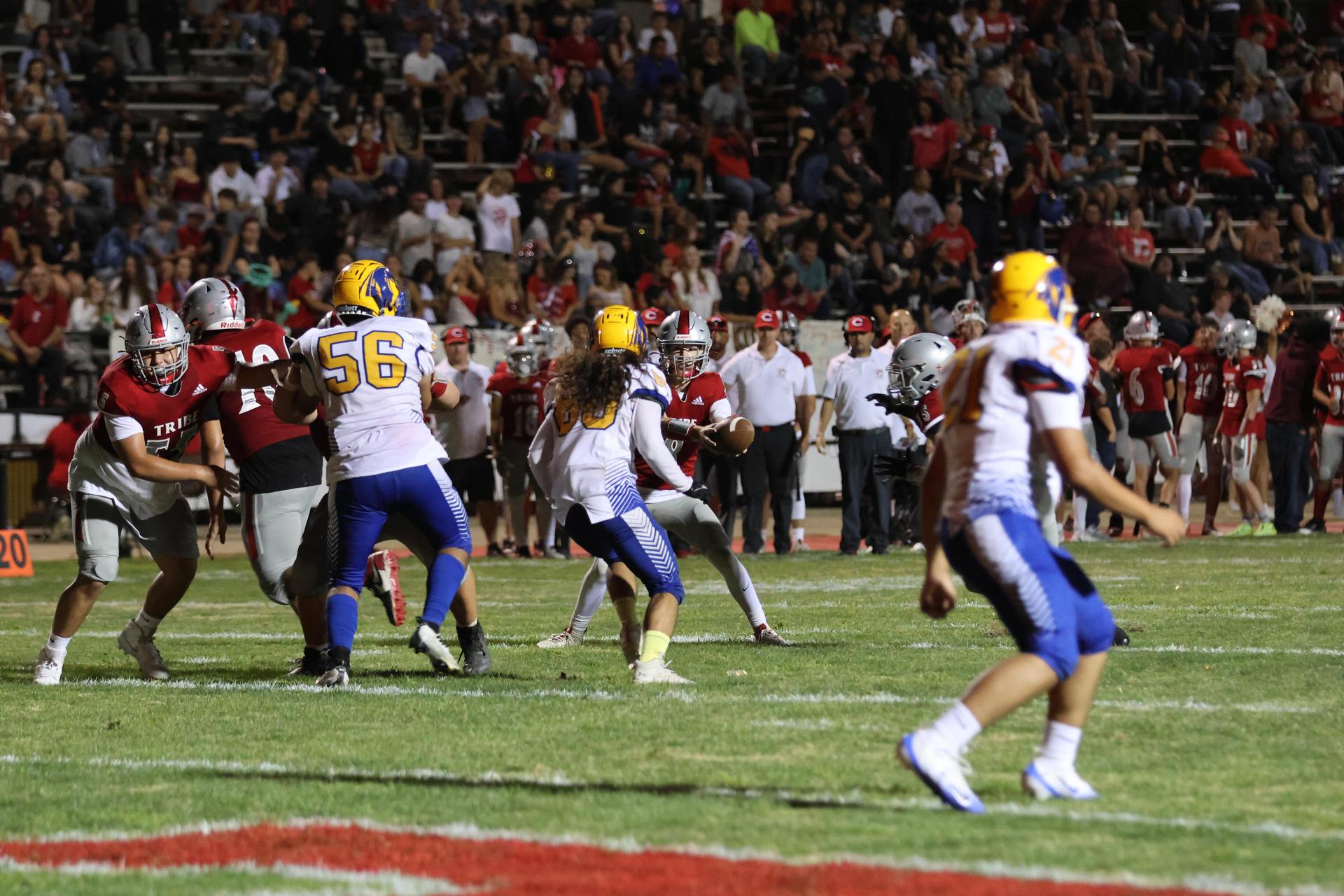 Varsity football players in action against Parlier 63