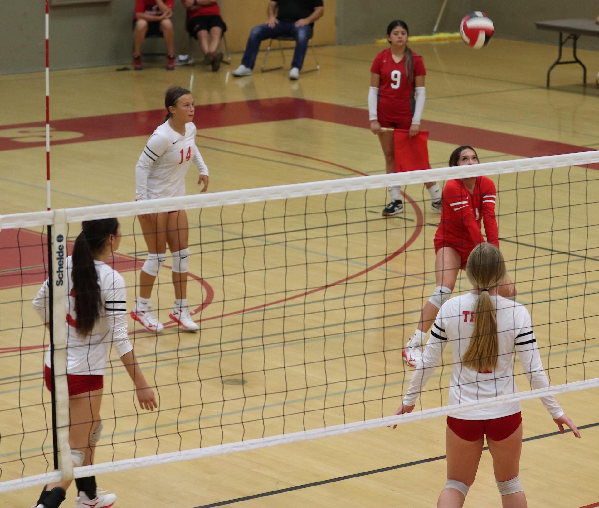 varsity volleyball players in action against Fresno Christian
