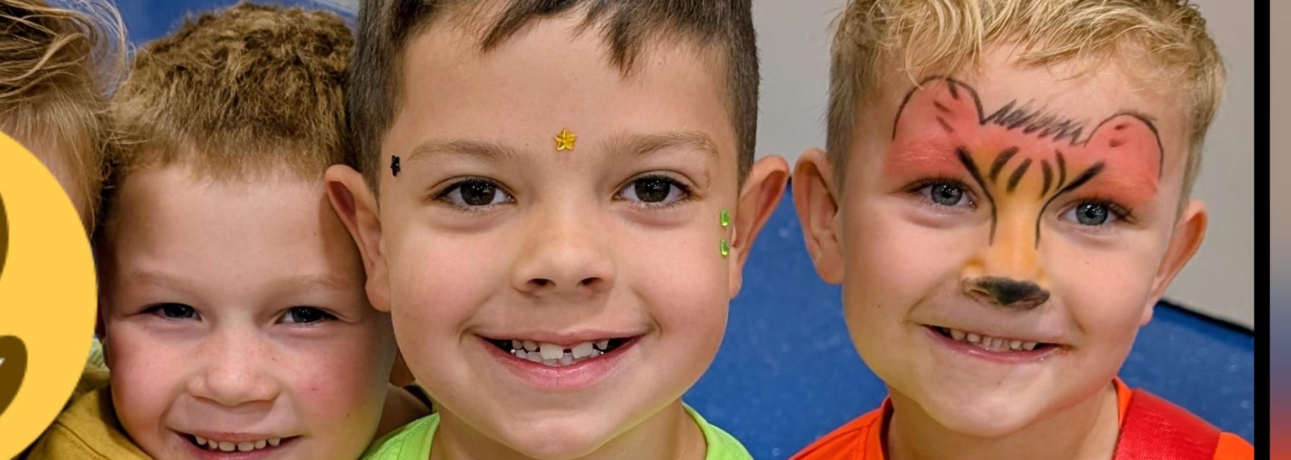 Three boys posing with light-up bags, one with a smiley face over the head.