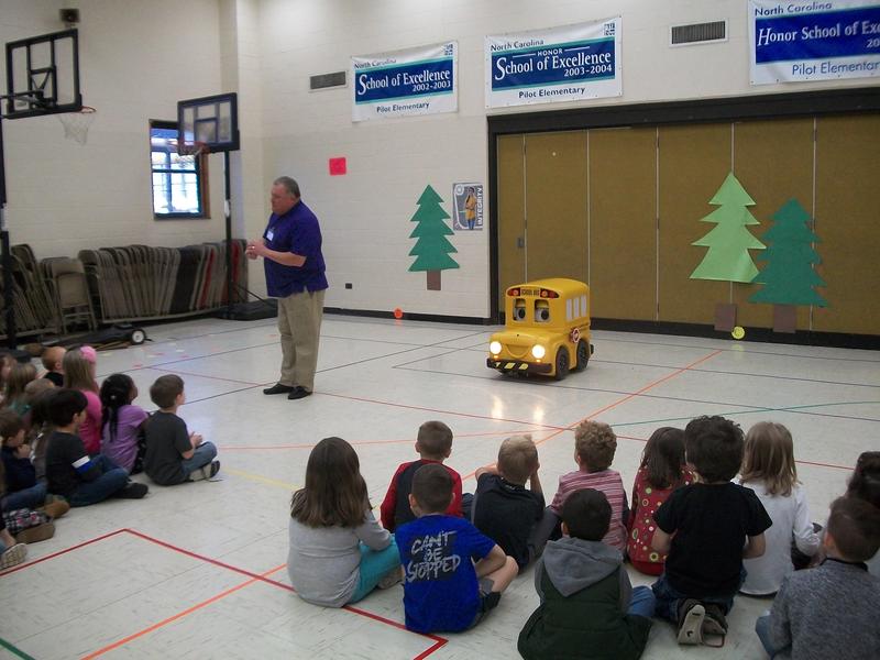 Buster the Bus visiting with kindergarten students in the gym.