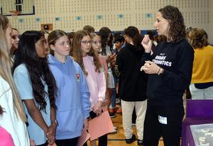 Woman explaining to a group of girls at a school event.