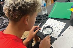 11th-grader Aiden Drotos identifies minutiae with a magnifying glass