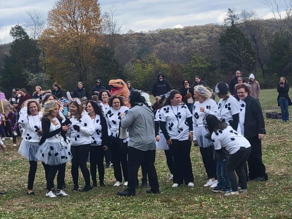 Springfield faculty and staff dressed in costume and standing together out on a grassy field.