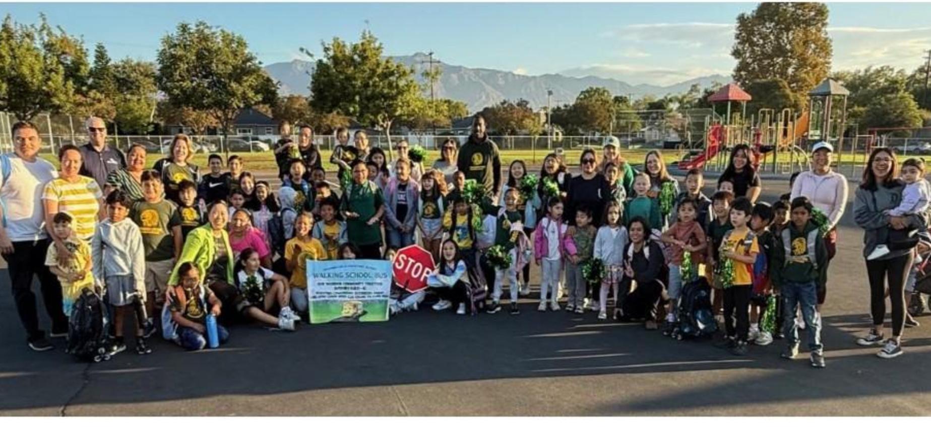 Large group of children and adults posing together at a schoolyard event.