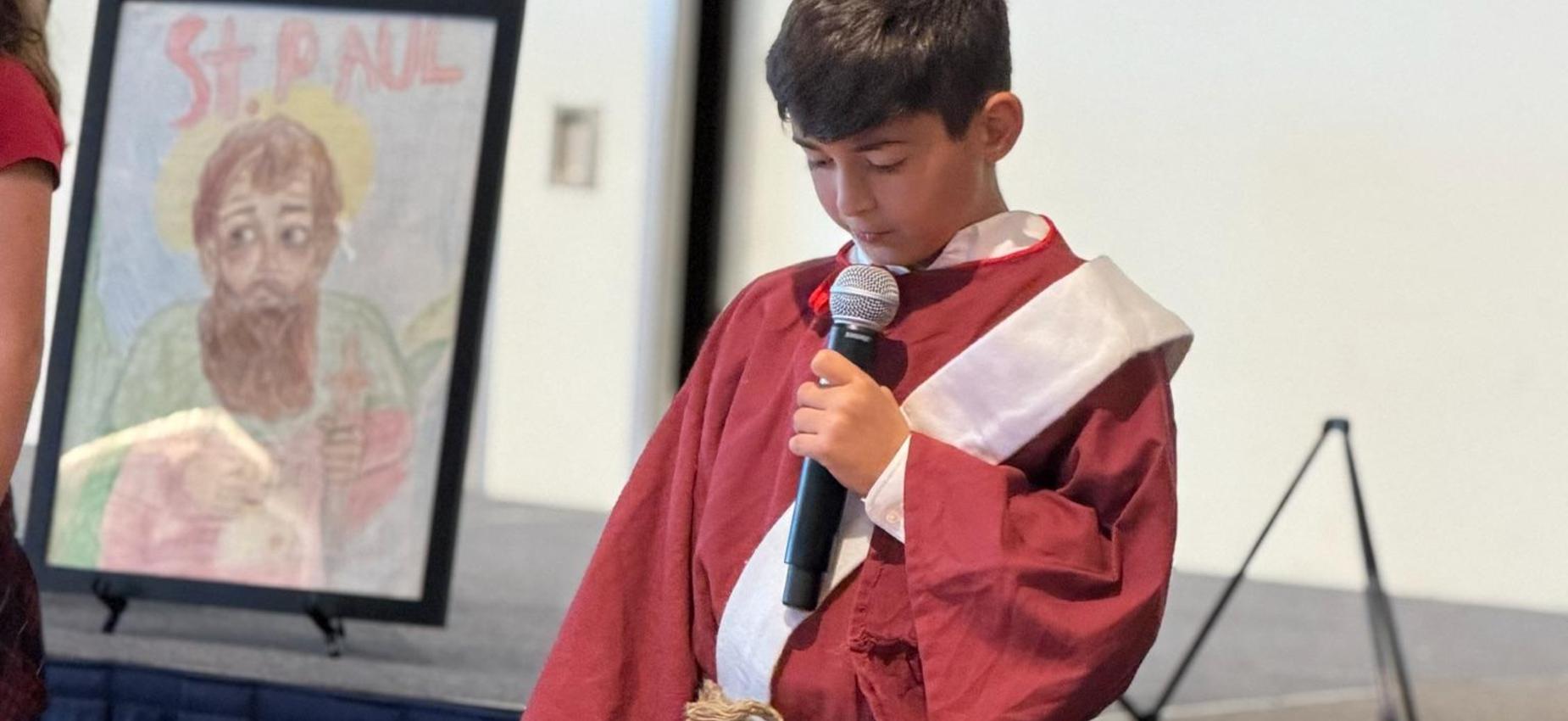 a 5th grade student dressed as St. Paul presents about the saint's life.