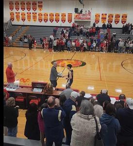 basketball player shaking hands with coach on basketball court