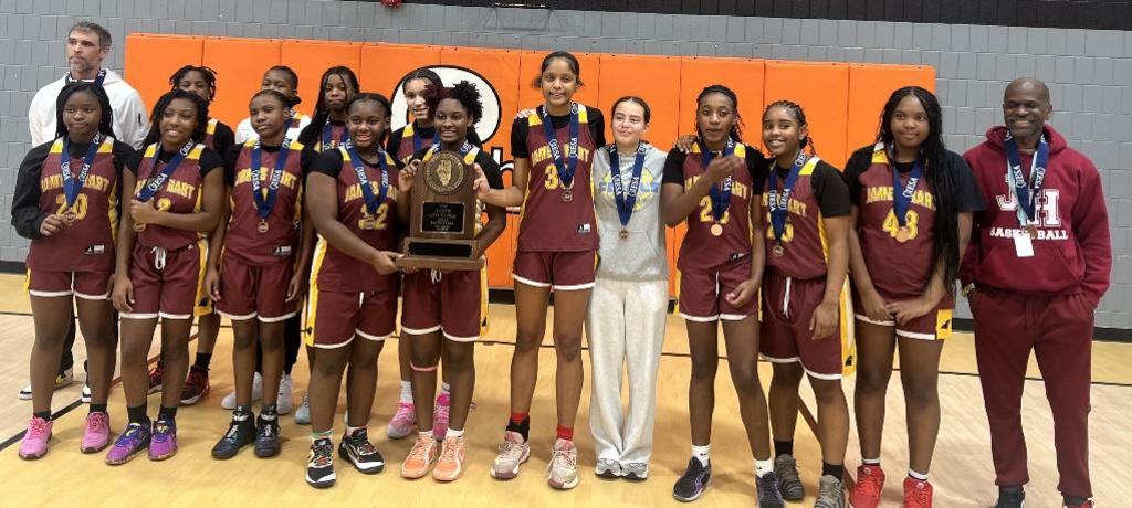 girls basketball team wearing medals and holding 4th-place state trophy