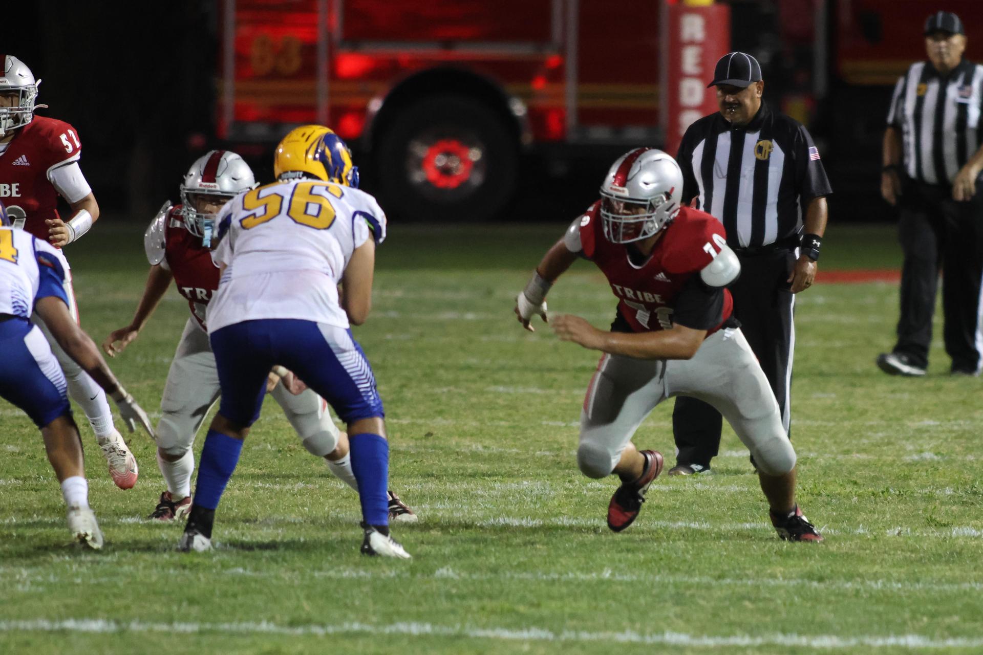 Varsity football players in action against Parlier 157