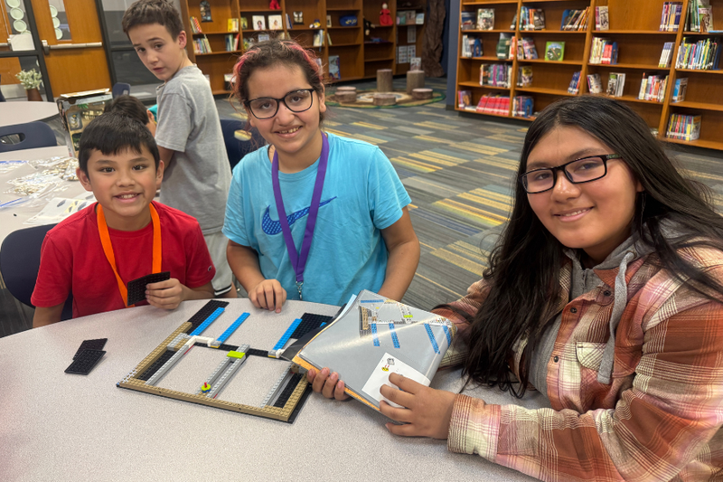 Three Ridgewood students working on a LEGO project in the library