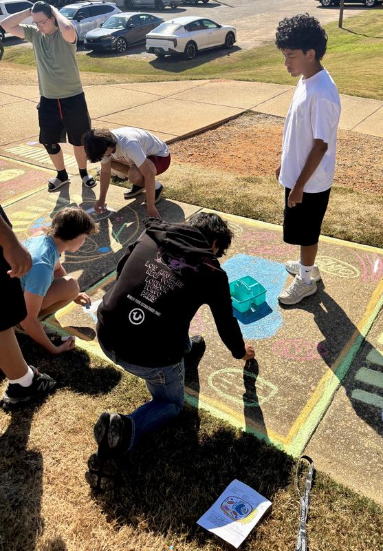 Group of students working on sidewalk art of the cell