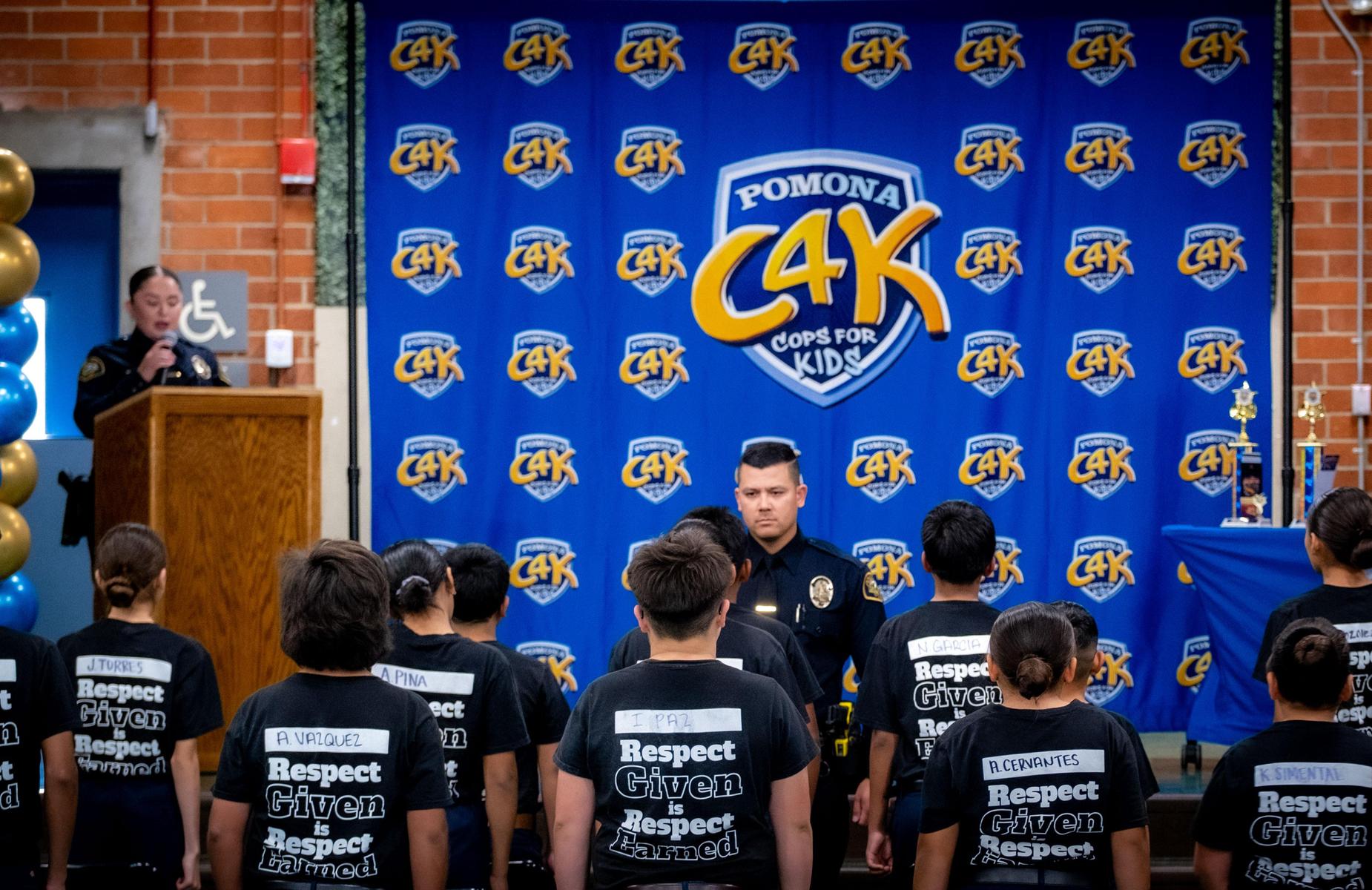 students stand at attention infront of Police officer