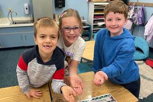Marcus Mays, Adelyn Schmidt, and Santino Loffredo hold worms from the compost