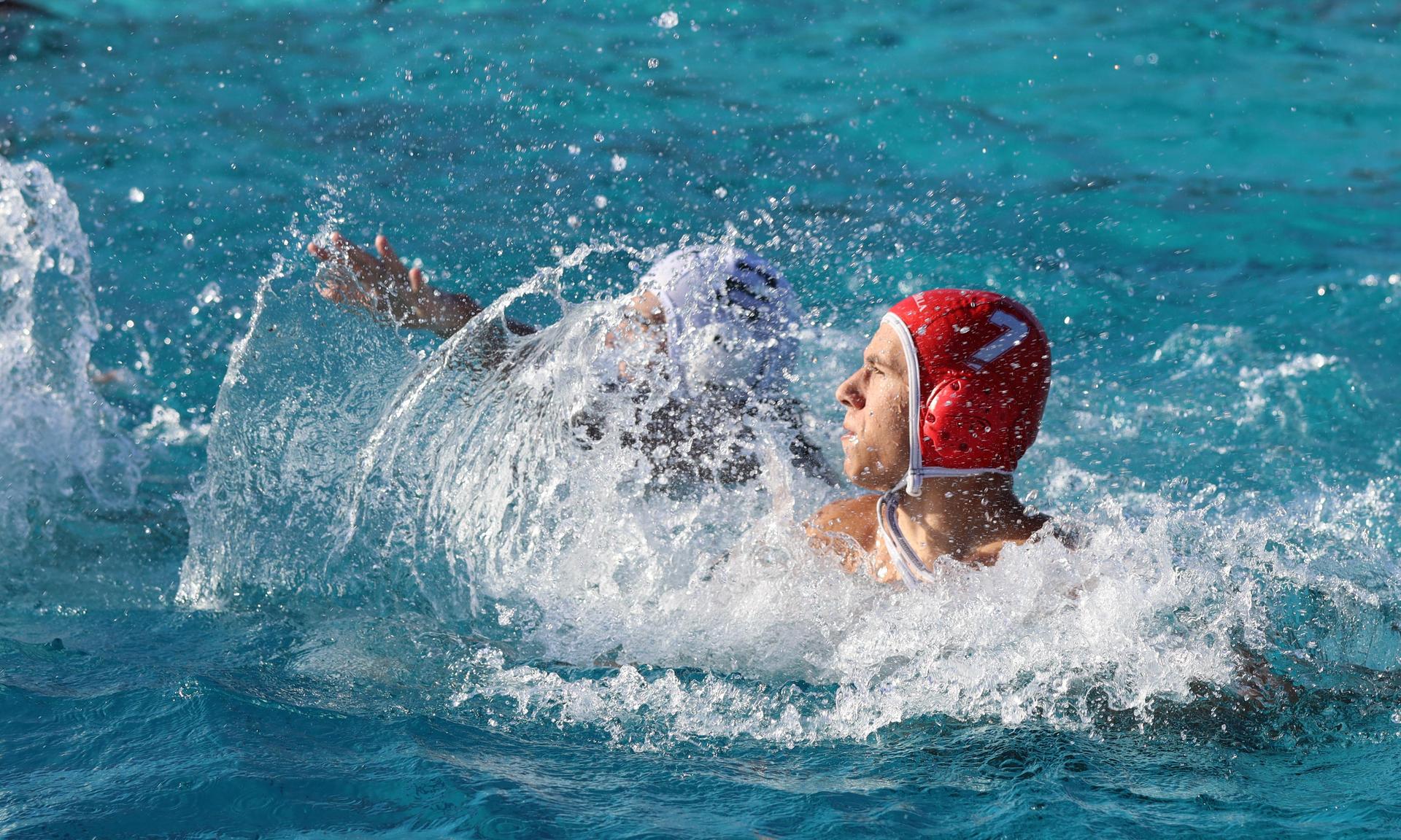 boys water polo players in action against hoover