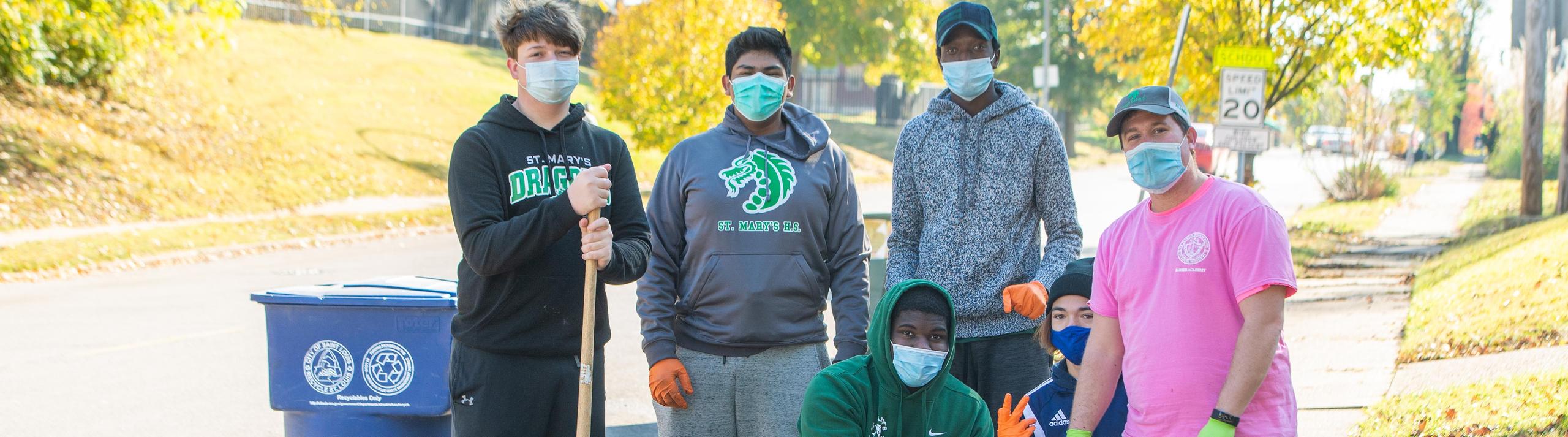 Members of the Barber Academy working together to clean up streets in South City.