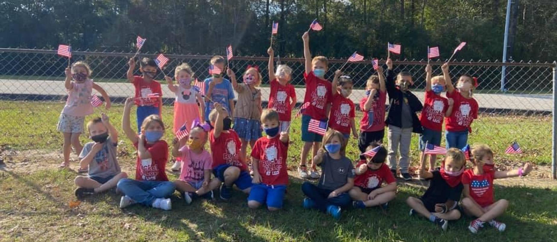 Early Childhood students waving US flag