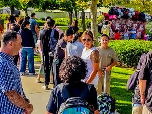 students walk and take pictures wuth parents