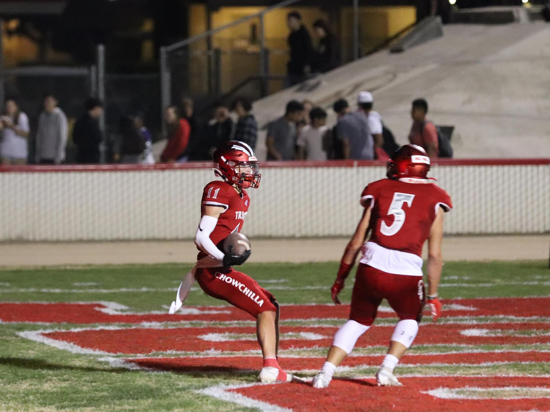 varsity football players in action against Riverdale