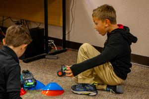 Boy playing with toys and a robot on the floor.