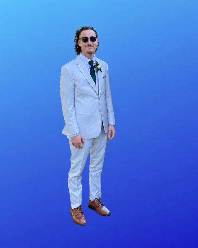 man stands in suit with blue background
