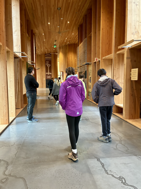 Visitors walking through a wooden hallway in a nature center.
