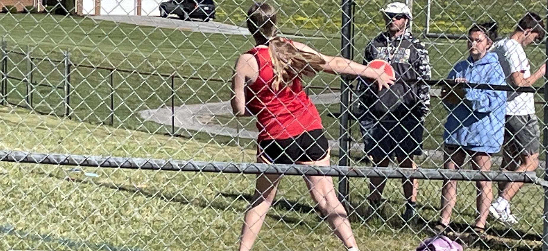 A girl throws a discus.