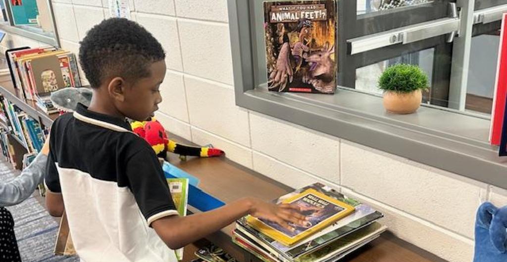 student looking for book in media center