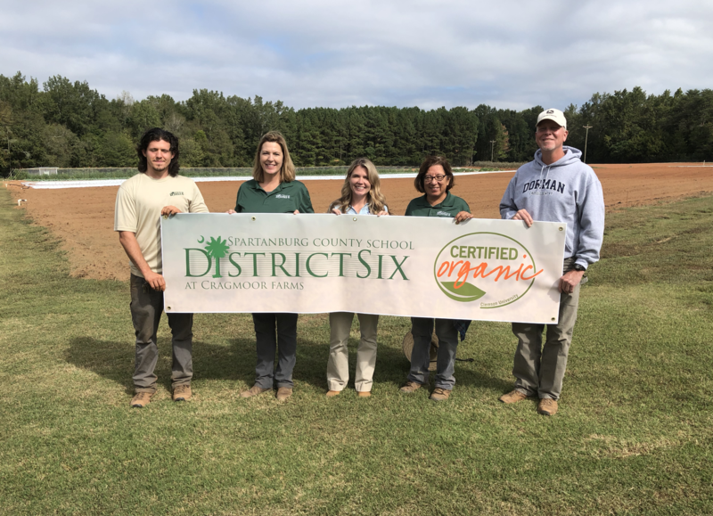 Farm team poses with a banner