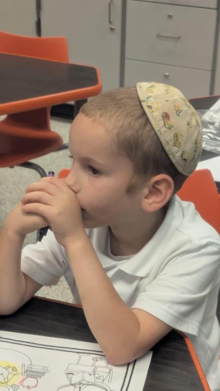 A boy listening intently to Rabbi Freundlich