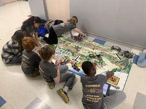 Robotics team members drive their robot through mission games