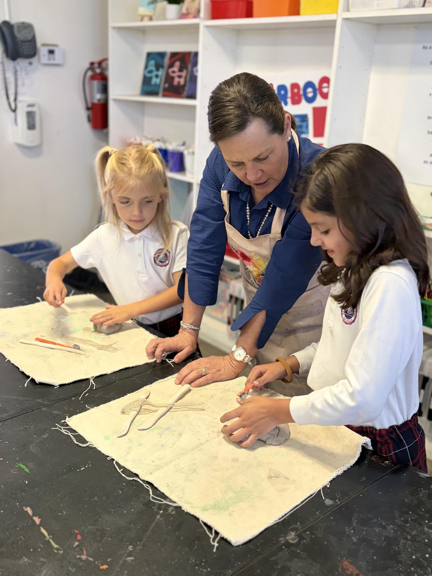 art teacher working with two students