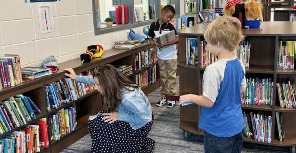 Media Specialist helping student find a book.