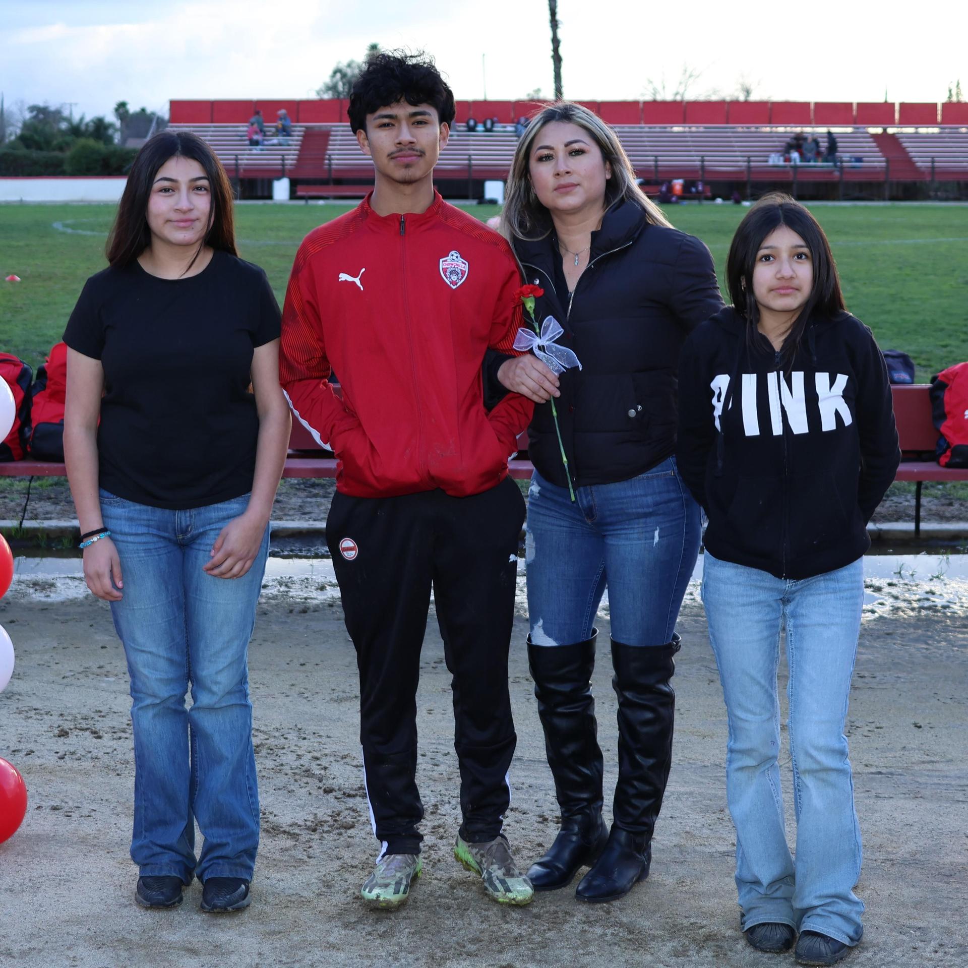 seniors and their escorts posing beneath a balloon arch