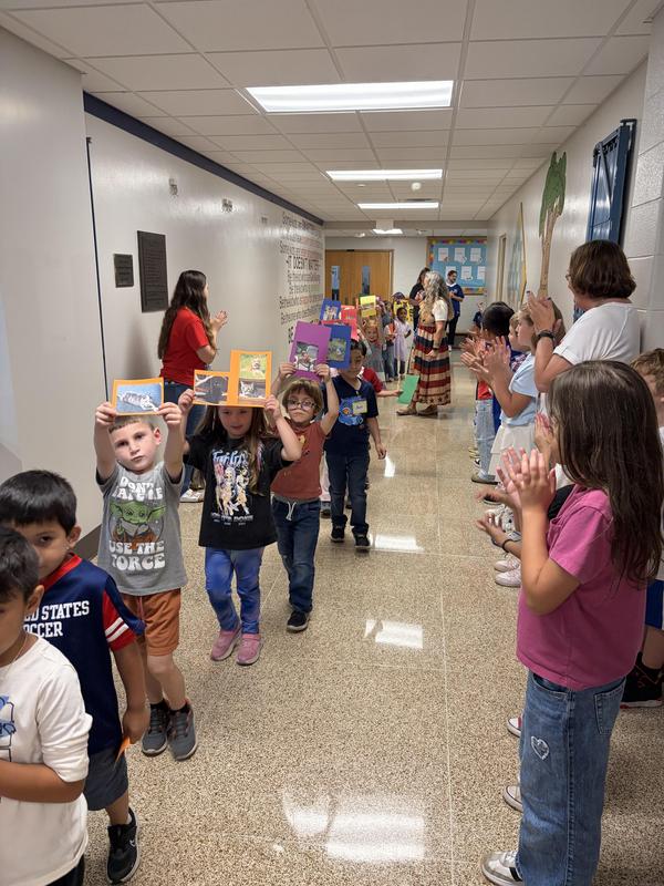 Students holding pictures of their pets