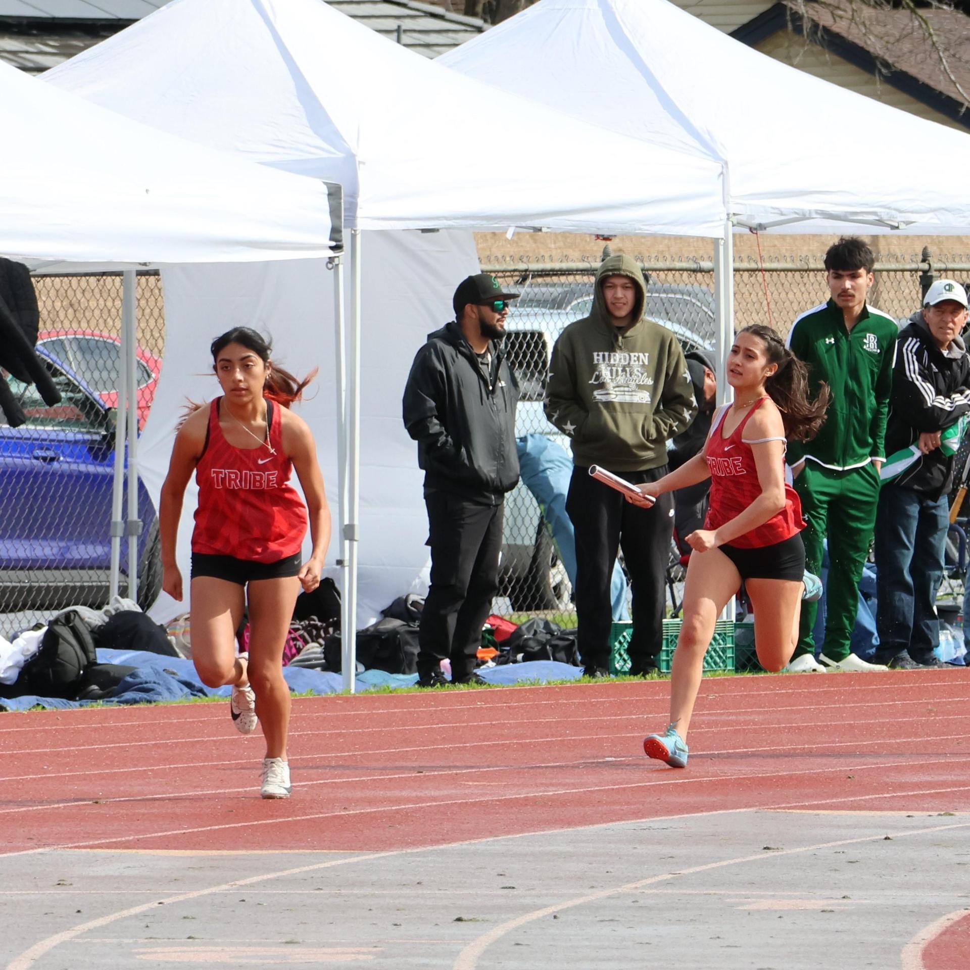 girls running the four by 100 meter relay