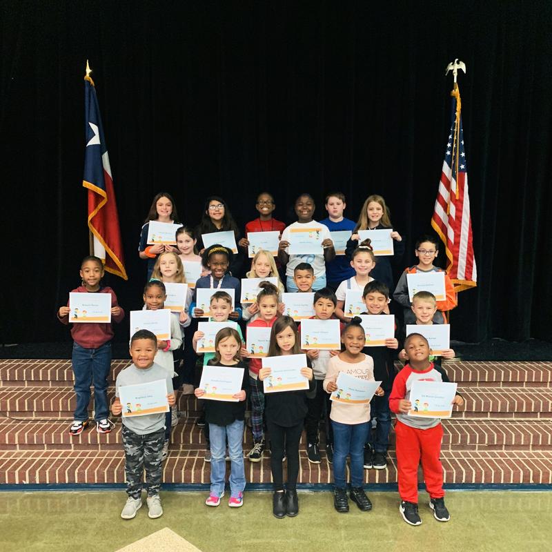 group of 24 students pose on stage steps