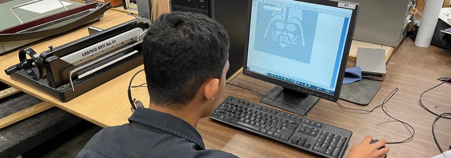 Student creating a graphic arts design