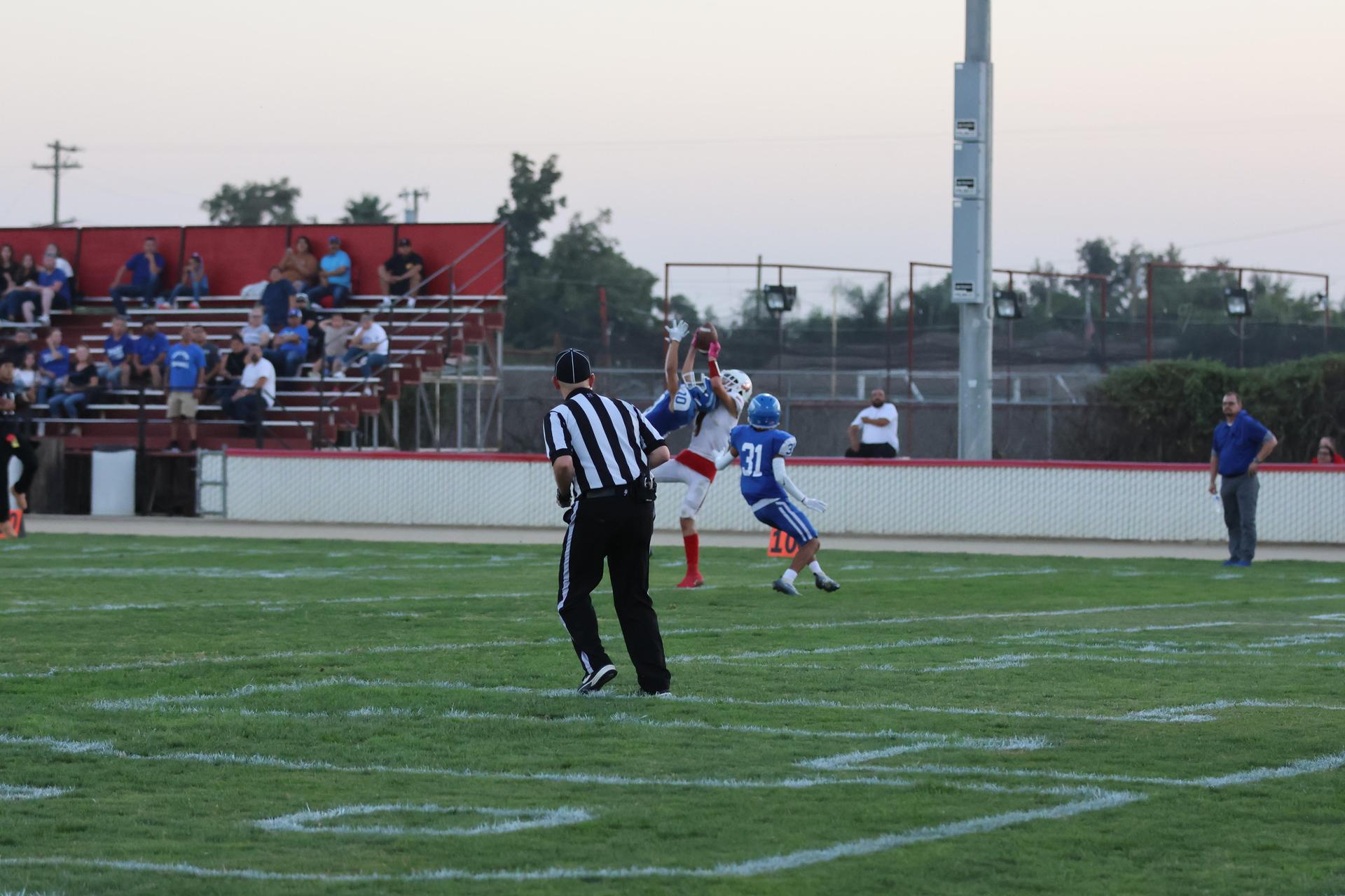 Junior Varsity football players in action against Caruthers